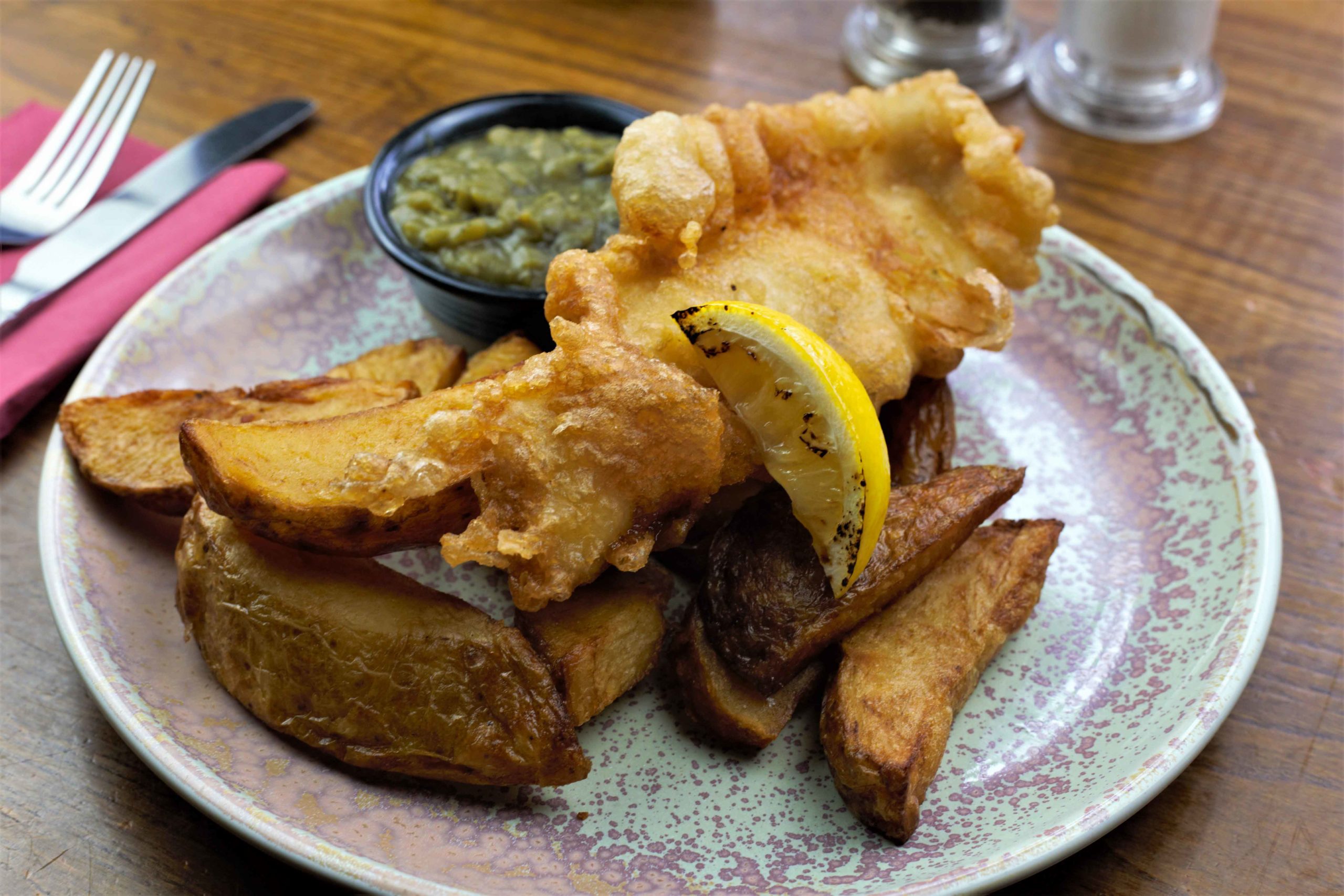 Fish and chips with mushy peas and grilled lemon wedge
